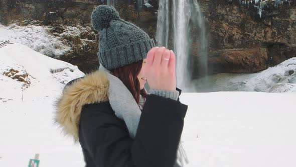 Woman Traveler Under Famous Waterfall Seljalandsfoss in Iceland