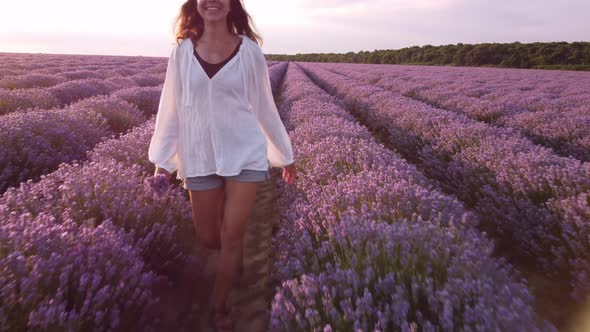 Young Woman in White Shirt Walking in Beautiful Lavender Field