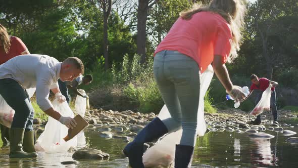 Mid adults volunteering during river clean-up day