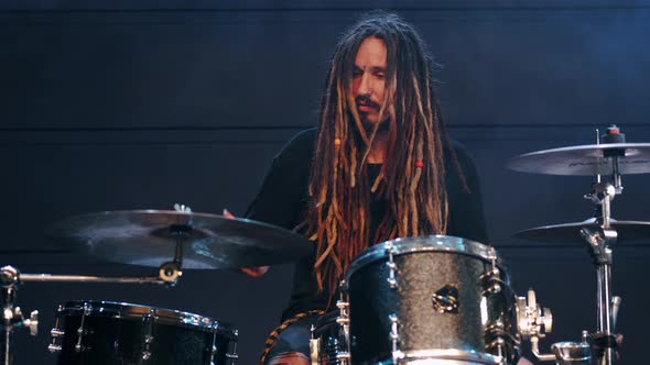 Talented Musician with Dreadlocks Play on Drums in Smoke in a Club