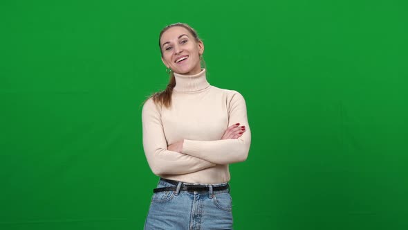 Positive Beautiful Woman with Crossed Hands Looking at Camera and Laughing