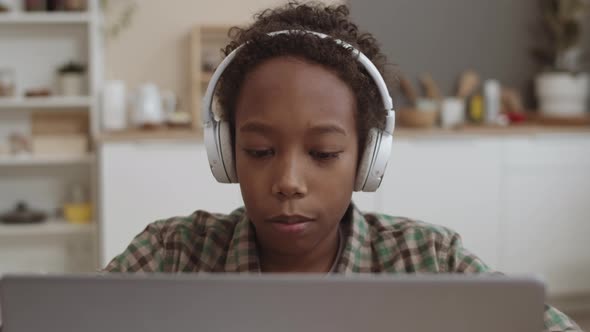 Boy with Headphones Using Laptop Computer