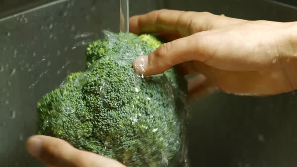 Male Hands Washing Broccoli.