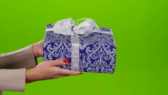 Box with a Gift Lovingly Packed in Blue Paper with Ornament