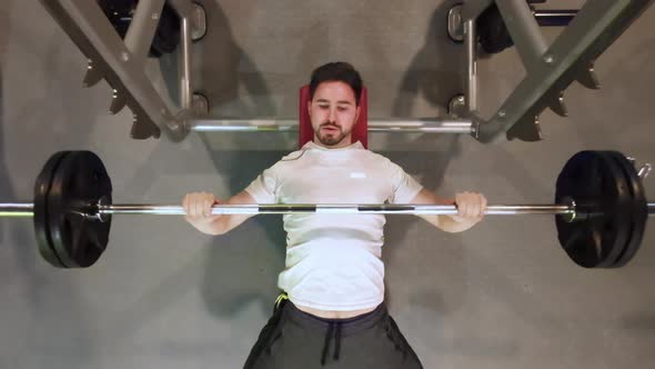 Young Fit Man with Beard In Gym Exercising Chest On The Bench Press