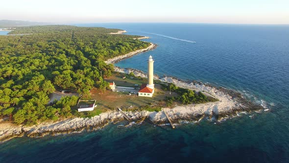 Flying over lighthouse, Croatia with a motorboat passing by