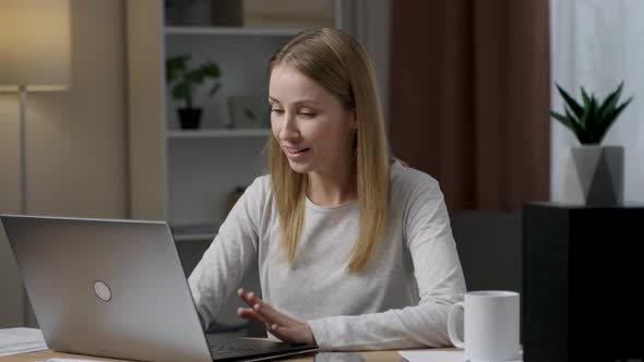 Communication on distance via video, video call. Young attractive woman using app on laptop