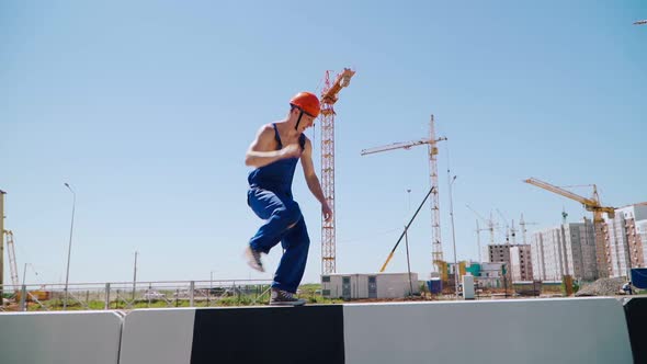 Happy Caucasian Man Builder in Hard Hat Dancing. Worker Funny Moves Background Construction Site