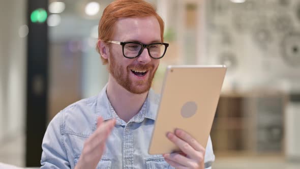 Portrait of Casual Redhead Man Doing Video Call on Digital Tablet 