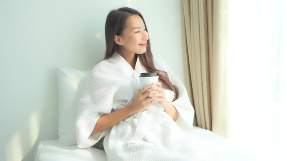 Asian woman relax on bed in bedroom interior