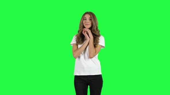 Lovable Girl Looking with Tenderness and Folded Arms in Front of Her. Green Screen