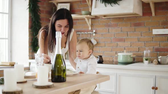 Happy Mother Giving Cookies to Her Little Son Boy in the Kitchen Happy Time Together