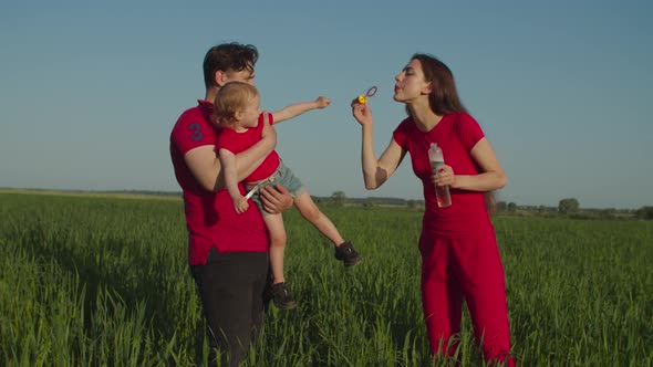 Excited Baby Girl Catching Soap Bubbles in Nature