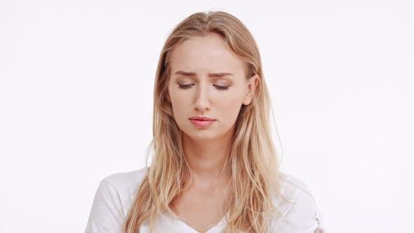 Sad Young Beautiful Caucasian Blonde Girl Trying Not to Cry on White Background in Slowmotion