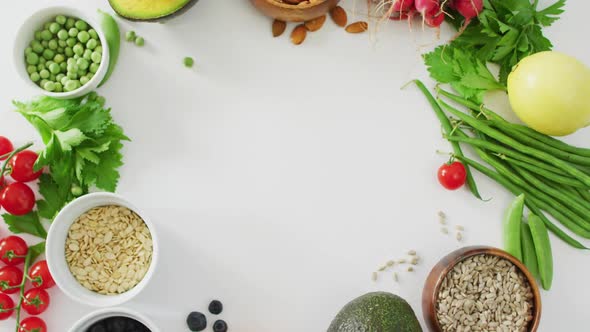 Video of fresh vegetables, seeds and berries with copy space on white background