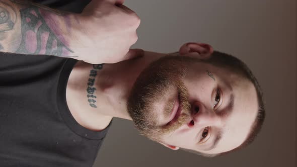 Vertical Video Young Tattooed Bearded Man Showing Aggressive Gesture Medium Closeup