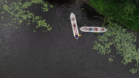 Aerial Birds-Eye View of Two Canoes Filled With People in a River in the Wilderness