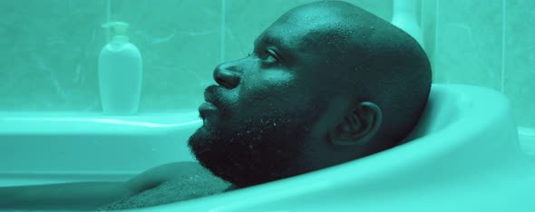 African American Man Relaxing in Bathtub