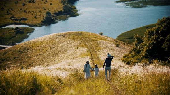 Family of Four Members Walking Down To the Wheat Field Near the River