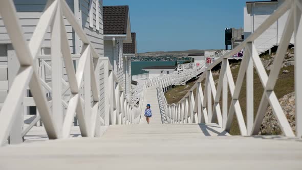 Boy Child in a Striped Blue Jacket and Bandana Walks