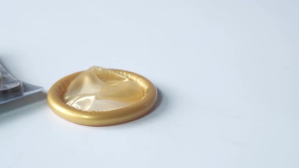 Close Up of Condom and Birth Control Pill on White 