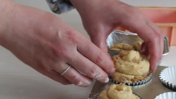 A Woman Prepares A Cruffin With Raisins And Candied Fruits. Puts The Dough Into A Mold.