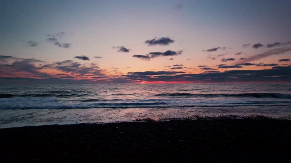 Drone Over Tide At Beach At Sunset With Horizon