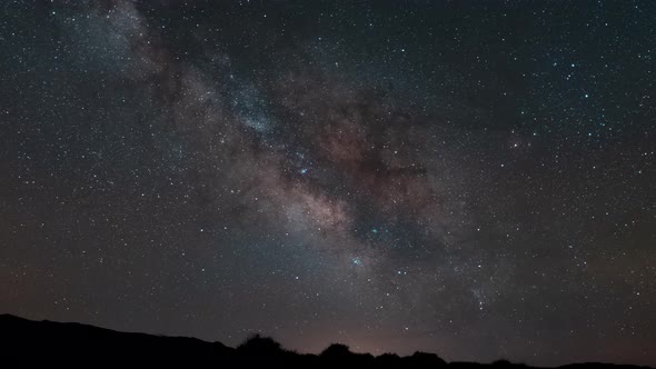 Tracking the Milky Way in brilliant color as it crosses the sky above the desert horizon - time laps