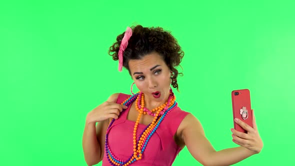 Young Woman Makes Selfie on Mobile Phone Then Looking Photos on Green Screen