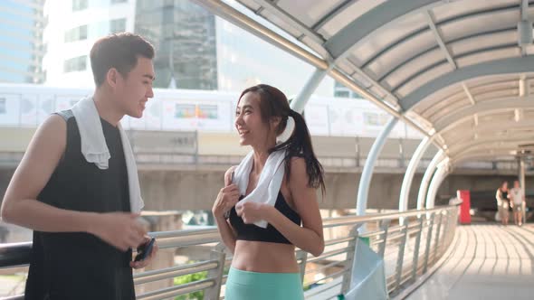Asian sport woman greeting with sport man during jogging in city and they look happy