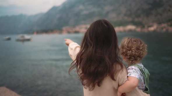 Loving Tender Asian American Young Mum Holding Adorable Cute Baby Boy Daughter Embracing Kissing