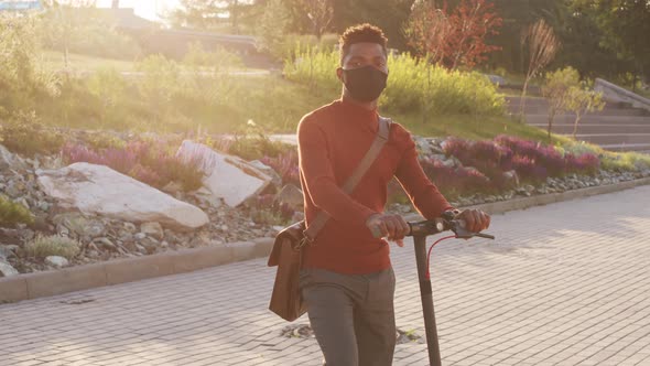 Portrait of African American Man in Face Mask with E-Scooter