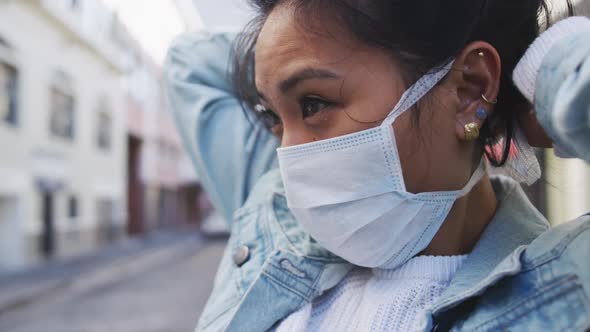 Woman fixing medical coronavirus mask on the street