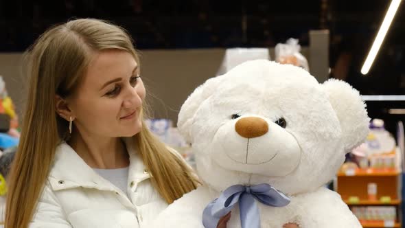 Beautiful blonde with a big soft teddy bear.