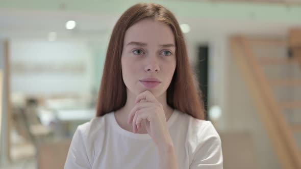 Portrait of Redhead Young Woman Thinking and Getting Idea