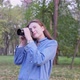Portrait of a Young Beautiful Woman Freelancer in an Autumn Park with a Camera - VideoHive Item for Sale