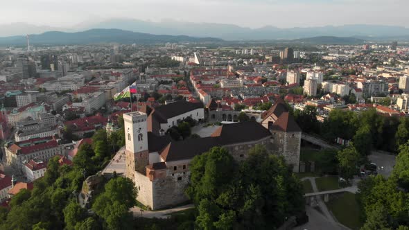 Flying over Ljubljana castle with drone in overseeing the city buildings