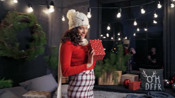 Positive lady with Christmas gifts. Attractive young woman sitting on bed among presents 