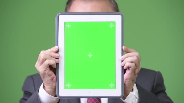 Mature Japanese Businessman Showing Digital Tablet
