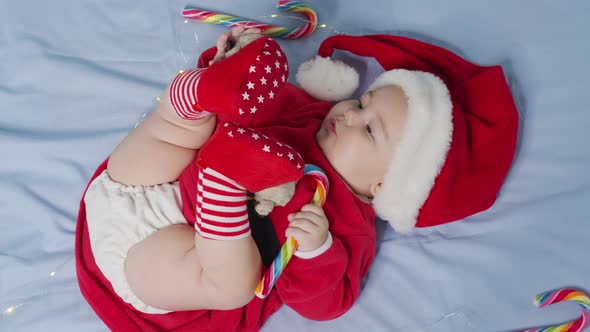 Christmas Portrait of Cute Little Newborn Baby Girl Wearing Santa Hat and Dress Winter Time