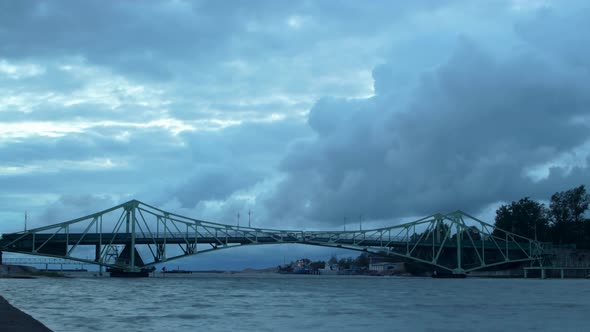 Time lapse of beautiful fasting dark gray rain clouds over the Oskara Kalpaka swing bridge in Liepaj