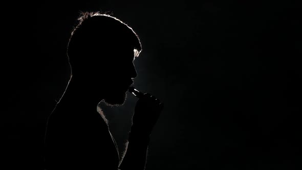 Portrait of a Bearded Man with a E-cigarette. Black. Silhuoette. Close Up. Slow Motion