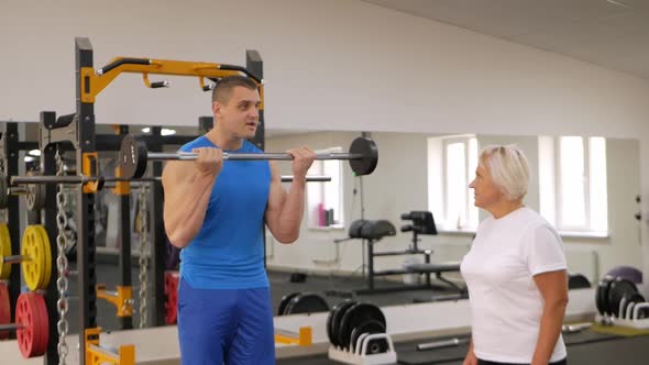 Elderly Woman is Engaged in a Sport in the Gym