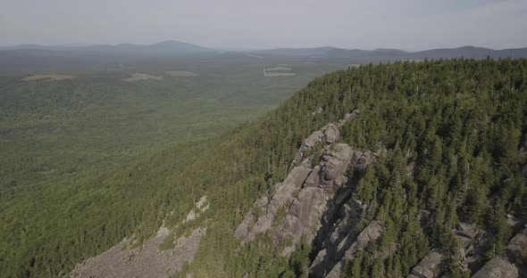 Aerial Drone Shot Flying Past Forest On Mountain Side