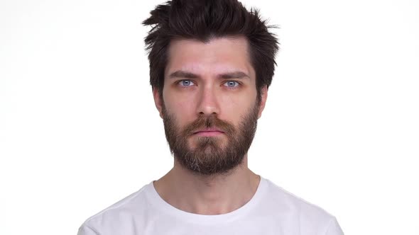 Young Male Looking Straight Raising Eyebrows Playful on White Background