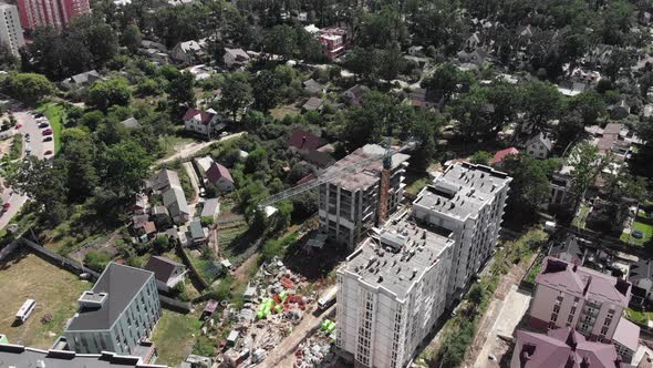 High construction crane is working on building site at residential modern complex