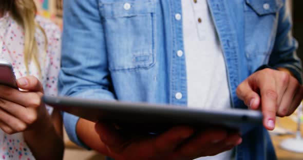 Group of business executives interacting over digital tablet and mobile phone