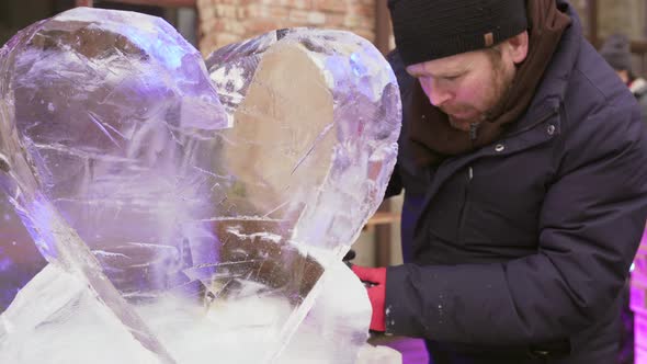 Man Doing Sculpture of Big Ice Heart