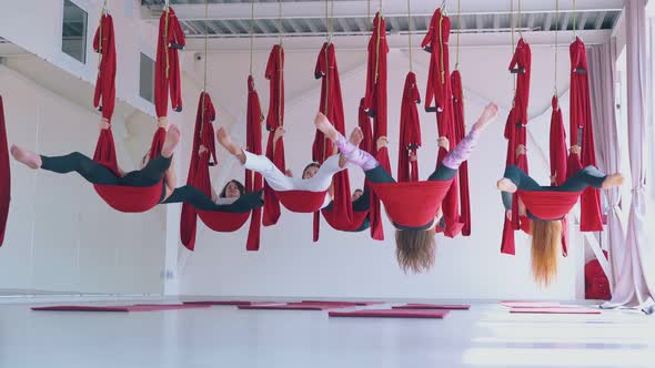 Skilled Ladies Group Hang Upside Down Holding Hammocks