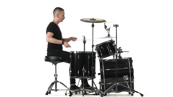 Man Professionally Plays Percussion Instruments, White Background, Side View. Slow Motion